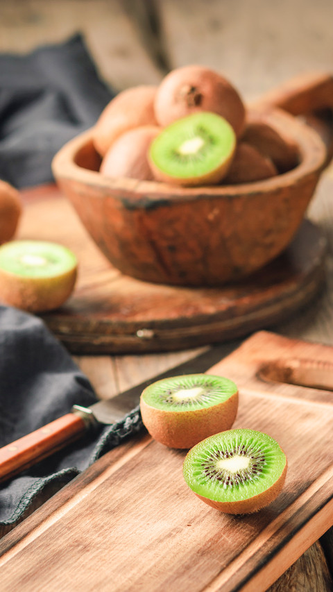 Organic fresh kiwi fruit on a wooden cutting board preview