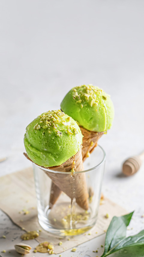 Two pistachio ice cream cones in a glass preview