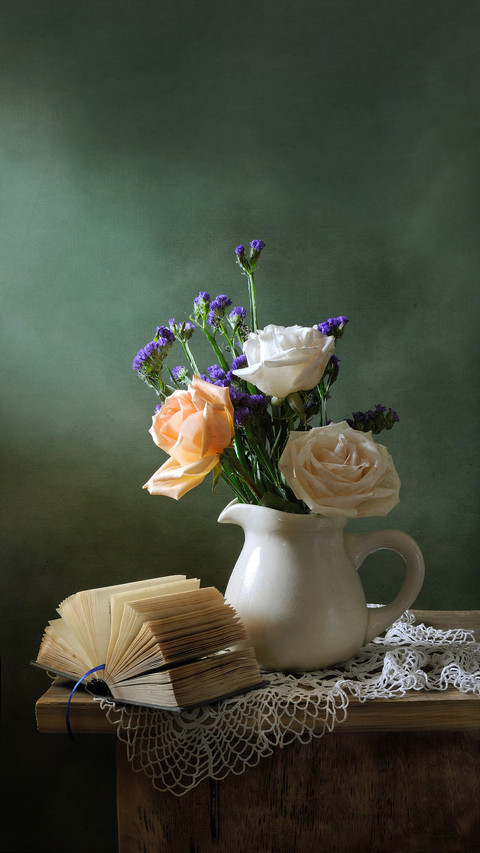 Romantic still life with a bouquet of roses and a book preview