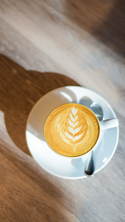 Latte art with sunlight and shadow on wooden background preview