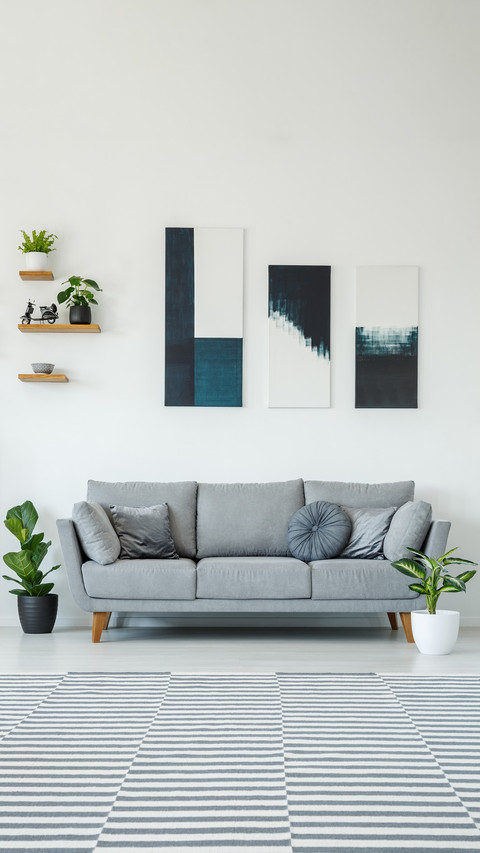 Posters above grey settee in bright living room preview
