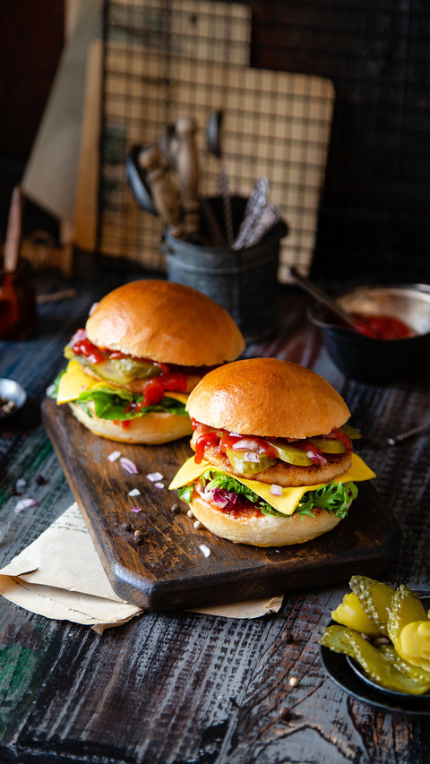Two homemade burgers with fried chicken on dark wooden table preview