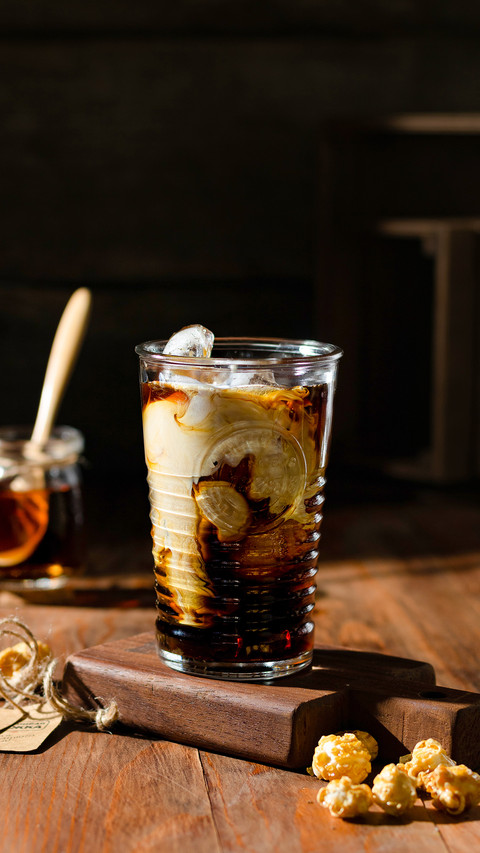 Iced coffee with cream on the table on a wooden board preview