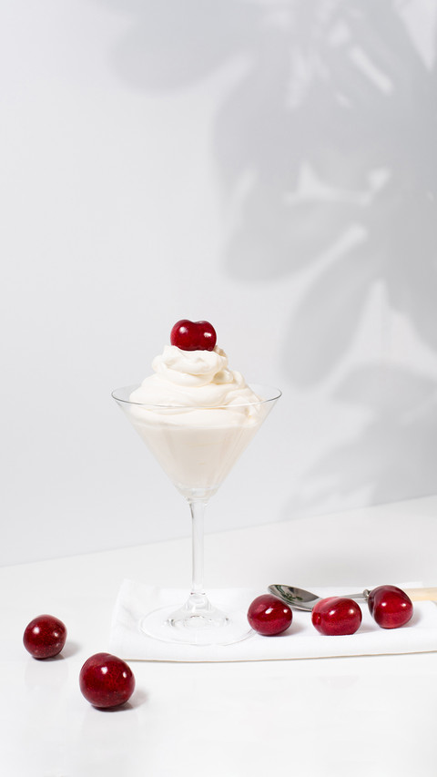 Ice Cream with Sweet Cherries in Cocktail Glass on table preview