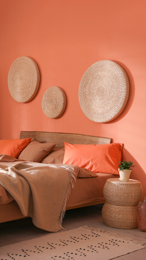 Bed with orange and brown linens in stylish room preview