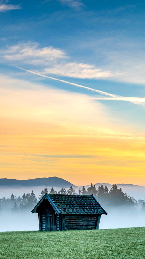 Mountain meadow with small hut with light ground fog preview