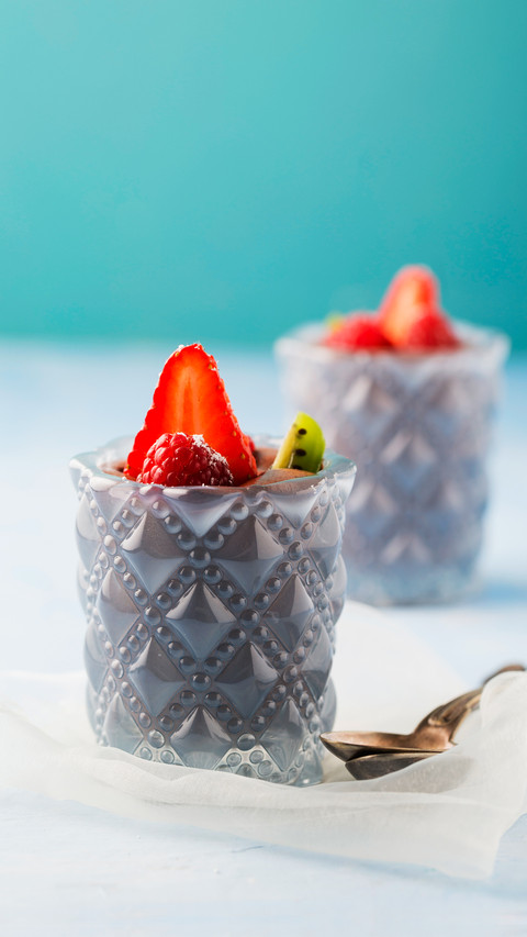 Glasses of mousse au chocolat garnished with raspberries preview