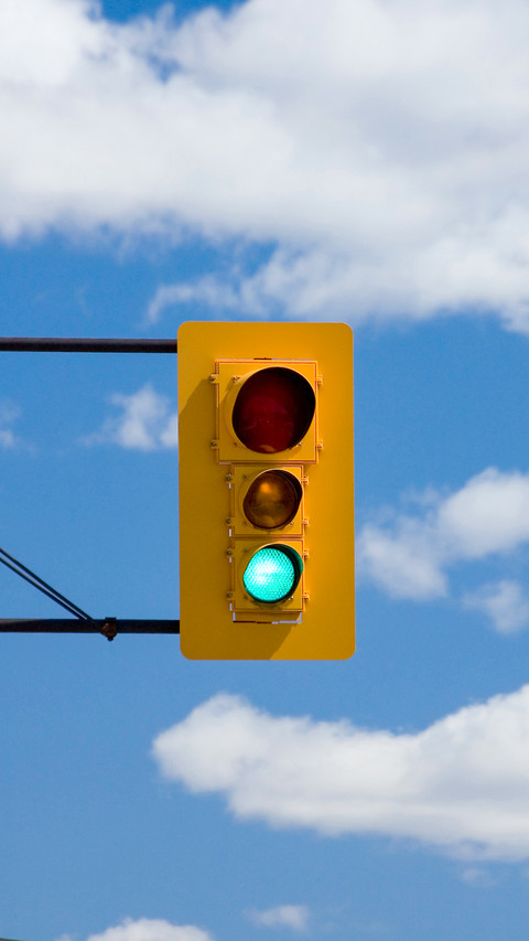 Traffic light against blue sky and clouds preview
