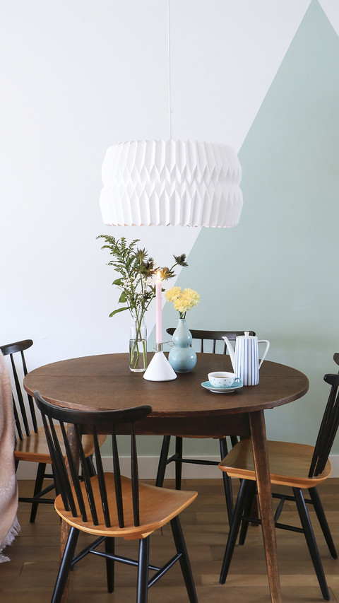 Round table and old chairs in front of twotone wall preview