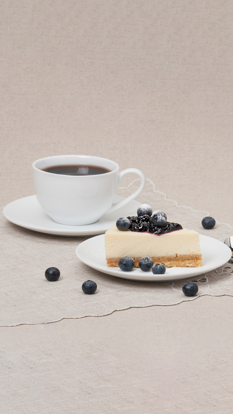 Cheesecake with blueberry jam and berries on white plate preview