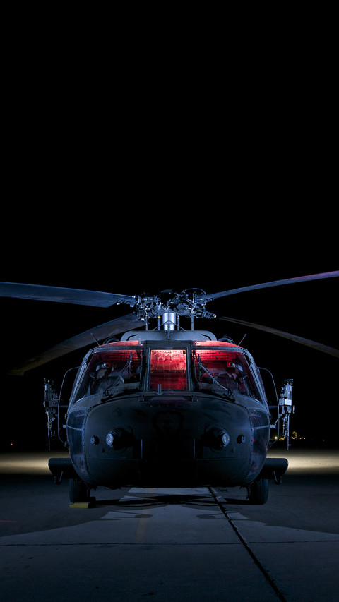 A uh60 black hawk helicopter lit up by multiple external preview
