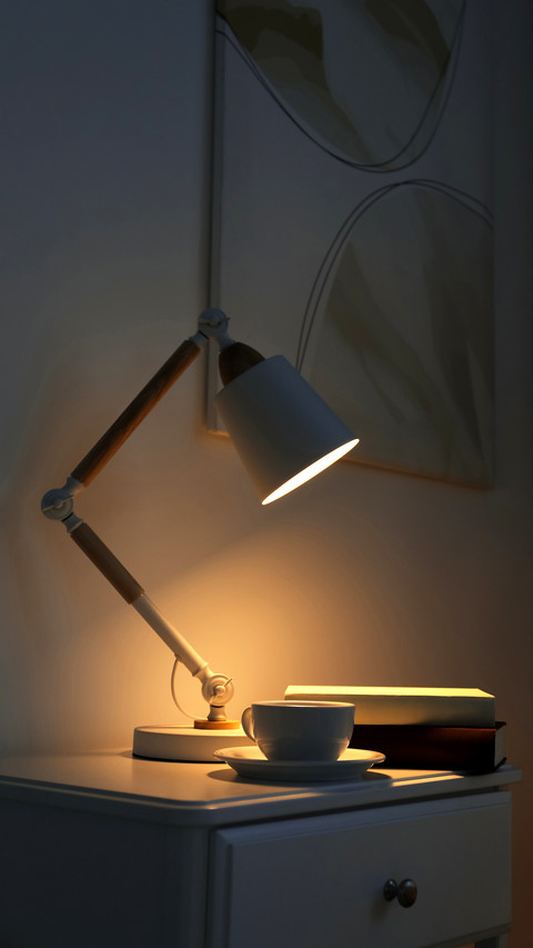Cup of drink and books on table in dark room preview