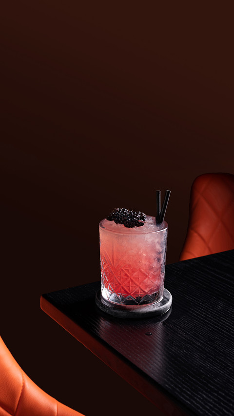 Negroni cocktail in dark bar with blackberries preview