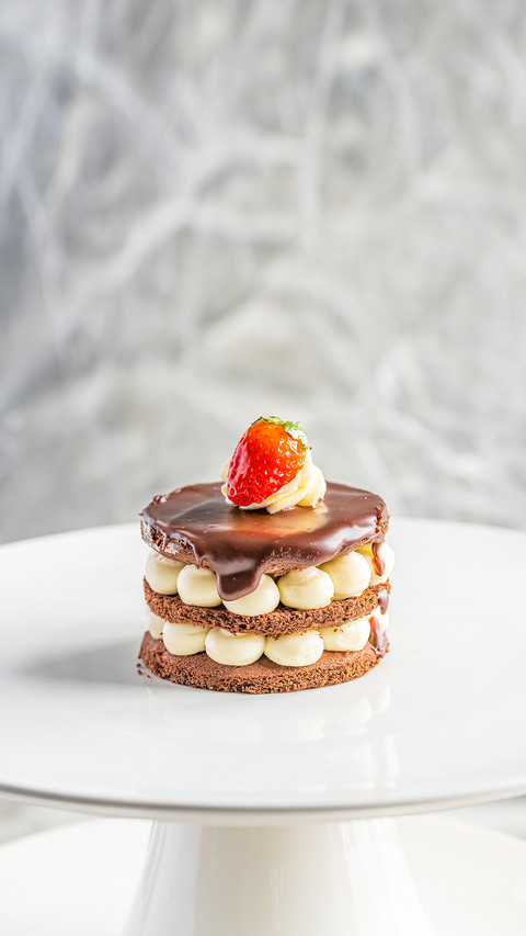 Piece of cake with cream and berries on a white plate preview