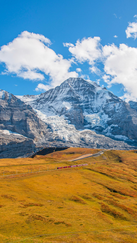 Landscape photo of Swiss Alps with clouds and meadow preview